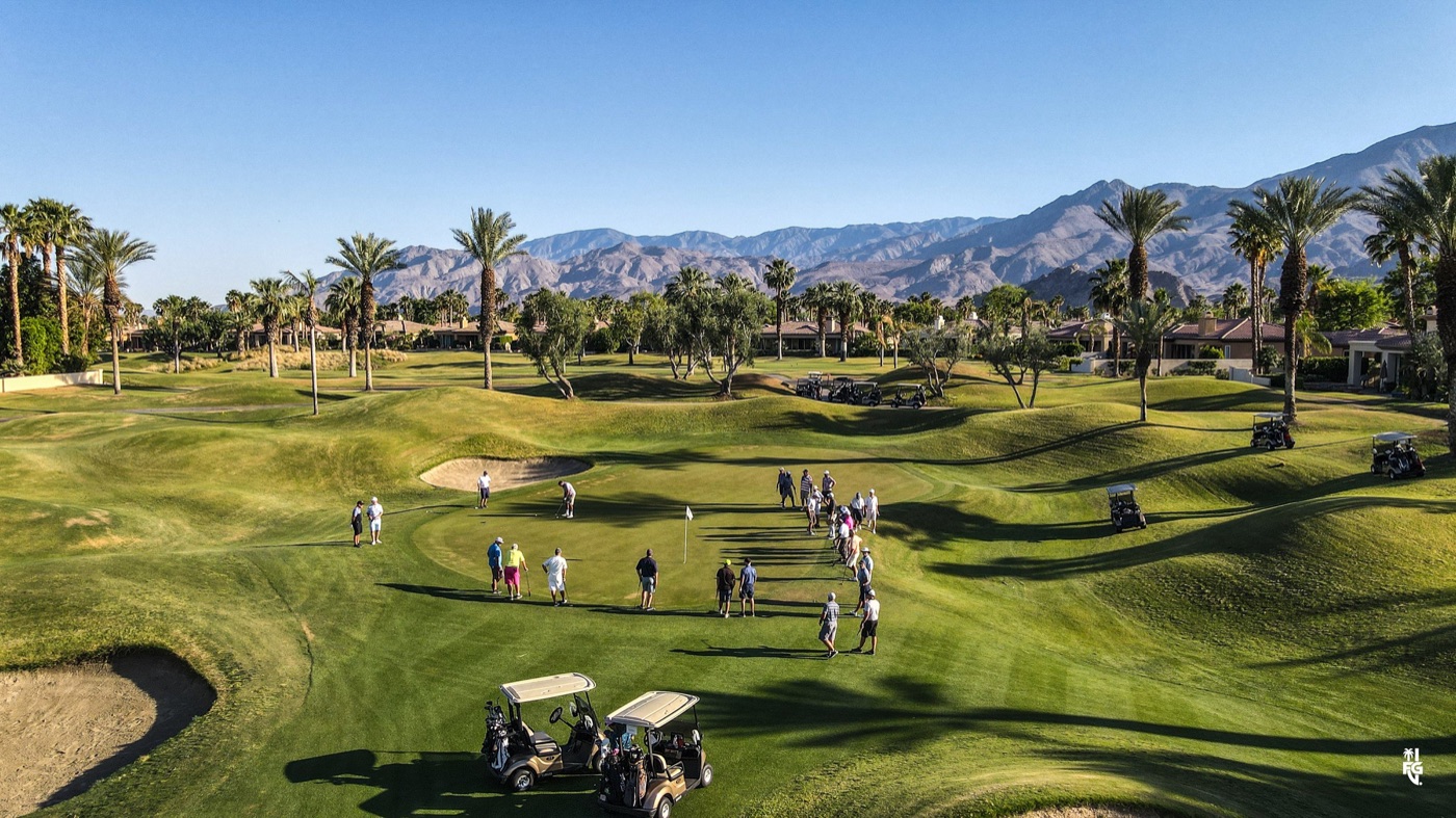 A crowd of golfers gathered around a green for a shootout