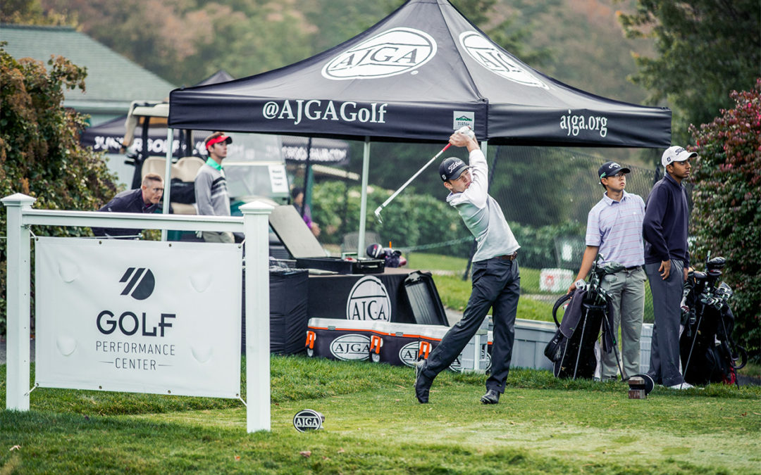 A junior golfer mid-swing at a tournament tee